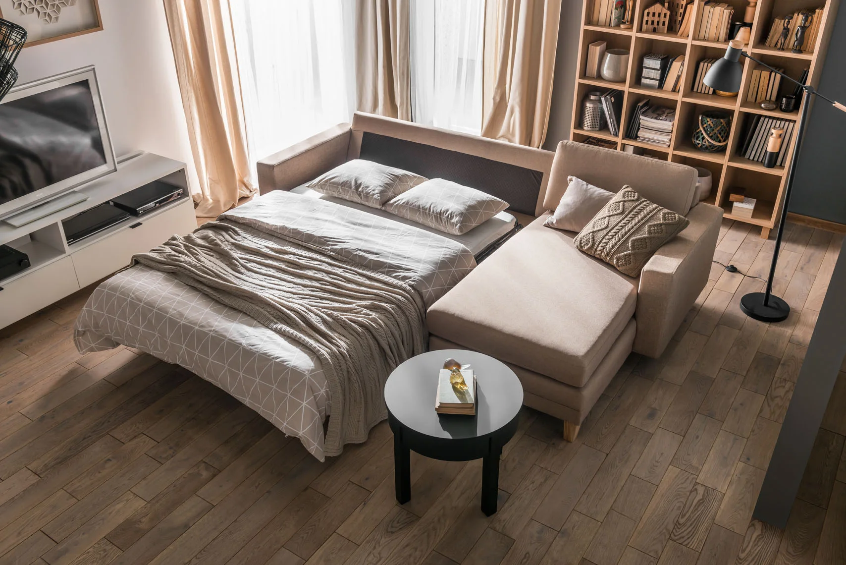Rozkładana sofa z pościelą w salonie